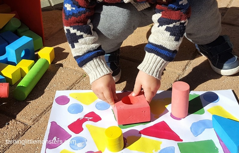 toddler painting with wooden blocks