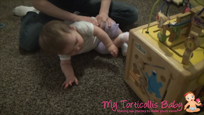 Baby with torticollis doing a physical therapy exercise with mother