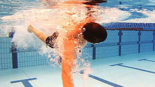 Underwater image of a swimmer rotationg too much in the water; Head excesively turned and well below the surface with stroking arm very low in the water: This article is about Head rotation in freestyle