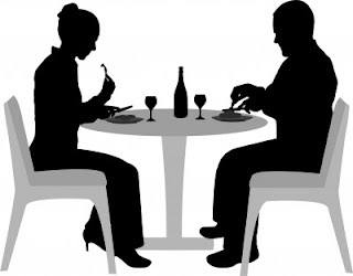 Black and white silhouette of couple eating and drinking at a dining table