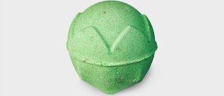 A green spherical bath bomb with a crown engraved into it on a bright background