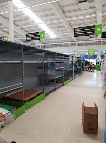 An ASDA store aisle completely empty with boxes on the floor