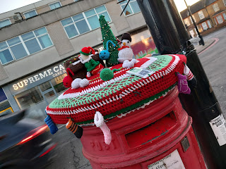 postbox topper in Christmas style with stockings hanging around the drum