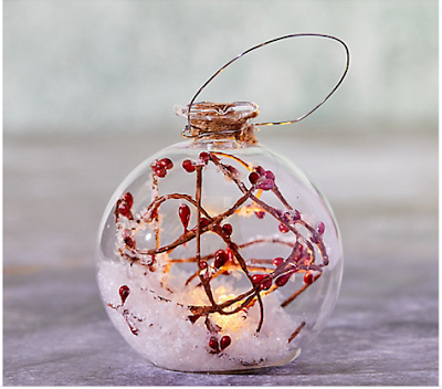 clear globe ball ornament filled with faux snow and red berries