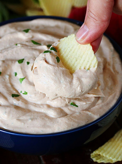 Dipping a Potato Chip in BBQ Chip Dip Image