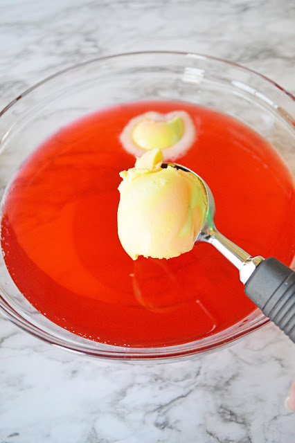 a scoop scooping sherbet into the punch bowl.