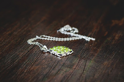 green necklace draped on a wooden surface