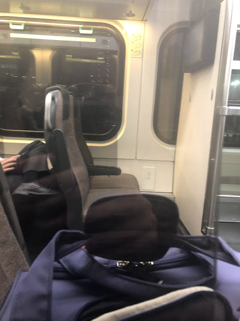 Empty train seats separated by plexiglass