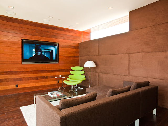 Picture of the movie room with wooden wall and dark brown sofa