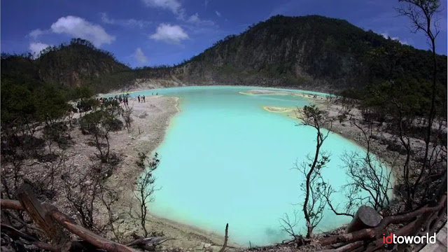 Kawah Putih is the most famous tourist spot in Bandung. Located in Ciwidey, West Java, Indonesia approximately 50 KM south of Bandung City.  Kawah Putih is a lake formed by the eruption of Mount Patuha. As the name implies, the soil in this region is white as a result of mixing sulfur elements. In addition to the white soil, Kawah Putih lake water also has a greenish-white color and can change color according to the sulfur content contained, temperature, and weather.    Ciwidey White Crater is located in a mountainous area which has an altitude of more than 2,400 meters above sea level. With this height, the air temperature in the White Crater area is naturally cold with temperatures of 8 degrees Celsius to 22 degrees Celsius, so don't forget to bring a jacket or wear thick clothes.    In addition to being enjoyed by tourists by its beauty. Kawah Putih Ciwidey is also often a place for other activities, for example film shooting, painting, bridal photographs, up to hiking and horse riding activities.    The story of the White Crater began in the 10th century where there was a great eruption by Mount Patuha. After this eruption, many people assumed that this location was a haunted area because every bird that flew past the area would die.    Over time, the belief about the haunted place began to fade, until finally in 1837 a botanist with German nationality came to this area to do research. The researcher named Dr. Franz Wilhelm Junghuhn was very interested in the quiet mountainous area where there were not even birds flying over him, so he toured the village in search of information. At that time, all the information he got was that the area was haunted and inhabited by ghost.  For Dr. Franz Wilhelm Junghuhn, the statement of the local community does not make sense. Because he did not believe these stories, he went into the jungle to find out what was there. Long story short, finally Dr. Franz Wilhelm Junghuhn made it to the top of the mountain, and from there he saw the existence of a beautiful white lake with a strong sulfuric odor.    Since then, the existence of the Crater of White Ciwidey became famous and starting from 1987 the government developed this area as a tourist spot that offers a unique experience of seeing a lake that can change color.