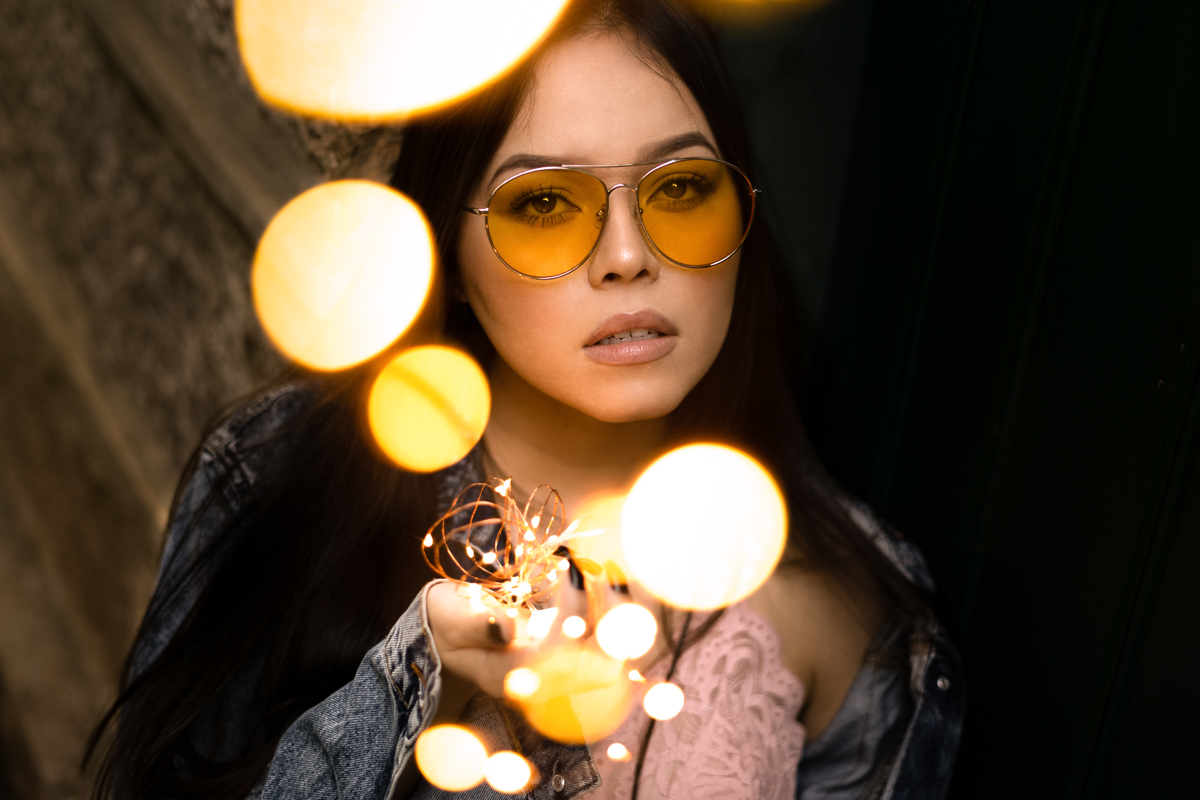 a portrait of a woman with beautiful makeup , she is wearing yellow sunglasses