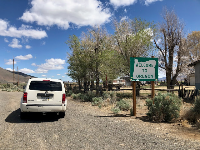 SUV by Oregon state line sign