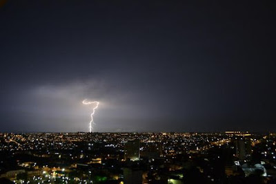   1 - O que é o trovão?,  Trovão é o som produzido pelo rápido aquecimento e expansão do ar na região da atmosfera onde a corrente elétrica do raio circula.  2 - A que distância pode-se ouvir o trovão?  Um trovão dificilmente pode ser ouvido se o raio acontecer a uma distância maior do que 20 quilômetros.  3 - Qual a intensidade do trovão?  A intensidade de qualquer som é geralmente dada em decibéis. Um trovão intenso pode chegar a 120 decibéis, uma intensidade comparável à que ouve uma pessoa que está nas primeiras fileiras de um show de rock.  4 - O trovão oferece algum perigo?  Embora o som ensurdecedor de um trovão assuste a maioria das pessoas, em geral ele é inofensivo. Contudo, o deslocamento de ar pode derrubar uma pessoa que esteja muito perto do local de incidência do raio, podendo até causar sua morte.  5 - Existem raios em outros planetas?  Sim, evidências de raios já foram observadas em outros quatro planetas do sistema solar: Vênus, Júpiter, Saturno e Urano.    6 - As cidades influenciam a ocorrência de raios?  Pesquisas já indicaram visíveis aumentos de incidência de raios em áreas urbanas. Essa maior incidência de raios está relacionada ao aumento de temperatura (fenômeno conhecido como ilha de calor) e de poluição nos centros urbanos.  7 - O raio pode atingir locais diferentes no solo?  Sim, um raio é formado por mais de uma descarga e algumas delas podem atingir o solo em locais diferentes. Em cerca de 50% dos raios negativos, mais de um ponto é atingido no solo.  8 - O que são raios?  Raios são descargas elétricas de grande intensidade que conectam o solo e as nuvens de tempestade na atmosfera. A intensidade típica de um raio é de 30 mil Ampères, cerca de mil vezes a intensidade de um chuveiro elétrico. A descarga percorre distâncias da ordem de 5 km.  9 - Qual a duração de um raio?  Um raio pode durar até dois segundos, mas dura em geral cerca de meio a um terço de segundo. No entanto, cada descarga que compõe o raio dura apenas frações de milésimos de segundos.  10 - Um raio pode cair duas vezes em um mesmo lugar?  Pode. Geralmente os raios caem mais de uma vez em um mesmo local quando este apresenta grande incidência de raios. Como exemplo podemos citar o monumento Cristo Redentor, que é atingido anualmente por cerca de seis raios.    11 - A energia de raio é grande?  Não. Embora a potência de um raio seja grande, sua pequena duração faz com que a energia seja pequena, algo em torno de 300 kWh, equivalente ao consumo mensal de energia de uma casa pequena.  12 - Um raio pode atingir diretamente uma pessoa?  A chance de uma pessoa ser atingida diretamente por um raio é muito baixa, sendo em média menor do que 1 para 1 milhão. Contudo, se a pessoa estiver numa área descampada embaixo de uma tempestade forte, esta chance pode aumentar em até 1 para mil. Entretanto, não é a incidência direta do raio a maior causadora de mortes e ferimentos. Geralmente são os efeitos indiretos associados a incidências próximas ou efeitos secundários dos raios que trazem risco. As descargas também provocam incêndios e queda de linhas de energia.  13 - Se uma pessoa for atingida por um raio, o que pode acontecer?  A corrente do raio pode causar queimaduras e outros danos a diversas partes do corpo. A maioria das mortes de pessoas atingidas por raio é causada por parada cardíaca e respiratória. Grande parte dos sobreviventes sofre por um longo tempo de sérias sequelas psicológicas e orgânicas.  14 - Como saber se o raio caiu perto?  A luz produzida pelo raio chega quase instantaneamente à visão de quem o observa. Já o som (trovão) demora um bom tempo, pois a sua velocidade é menor. Para obter a distância aproximada da queda do raio, em quilômetros, basta contar o tempo (em segundos) entre o momento em que se vê o raio e se escuta o trovão e dividir por três.    15 - Qual o local com maior incidência de raios no Brasil?  A região entre Coari e Manaus é a região que mais tem raios do Brasil. A região amazônica deverá ter um aumento na incidência do fenômeno nas próximas décadas.  16 - Por que o Brasil é o país campeão mundial em incidência de raios?  No Brasil, caem 50 milhões de raios por ano e a explicação é geográfica: é o maior país da zona tropical do planeta - área central onde o clima é mais quente e, portanto, mais favorável à formação de tempestades e de raios.  17 - O que são raios negativos e positivos?  Raios negativos são raios que trazem cargas negativas da nuvem para o solo e positivos são os que trazem cargas positivas.  18 - Qual a diferença entre relâmpagos e raios?  Relâmpagos são todas as descargas elétricas geradas por nuvens de tempestades, que se conectam ou não      Fontes Imagens: Arquivo Pessoal  Fontes: Questionário: INPE/ELAT - Grupo de Eletricidade Atmosférica