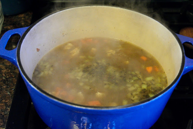 The chicken stock being added to the pot.