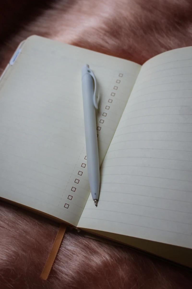 an opened diary with a pen on top of the page