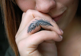 tatuaje pluma pavo real dedo