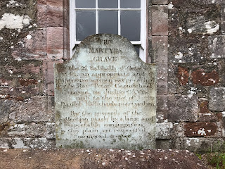 A photo of a grey coloured gravestone standing over a lower stone - on the stone are carved the words The Martyrs Grave.  Photograph taken by Kevin Nosferatu for the Skulferatu Project.