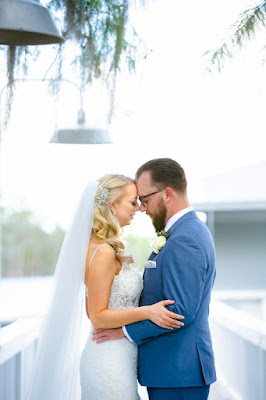 bride and groom forehead to forehead in front of lake