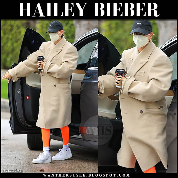 Hailey Bieber in camel coat and orange leggings