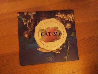 Real pot of jam themed around Alice through the looking glass with "eat me" written on the top