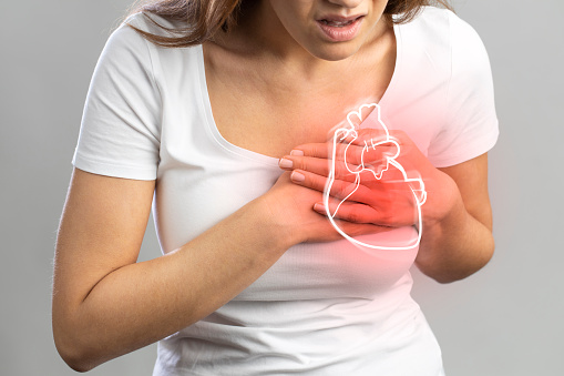 A lady suffering from heart problem holding her hand on her chest