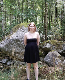 Photo of me standing in front of some huge rocks before a forest in Sweden