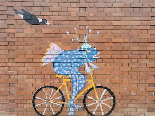 Fish riding bicycle mural in Dickson, ACT by Bev Hogg