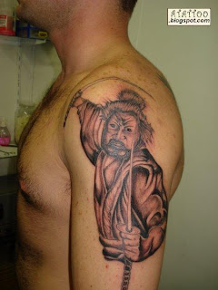 Samurai preto e cinza tatuado no braço.