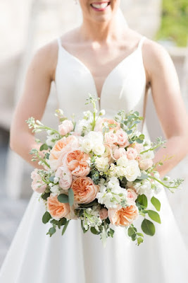 bride holding white and pink bouquet with roses