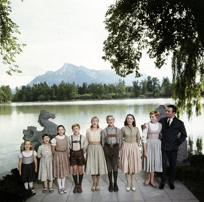 Pictured above: a film still from The Sound of Music, showing the actual location which was recreated with one of the iconic backdrops that will be seen by the public for the first time in this exhibition, 20th Century Fox (1965).