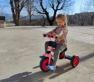 Rosie riding her tricycle