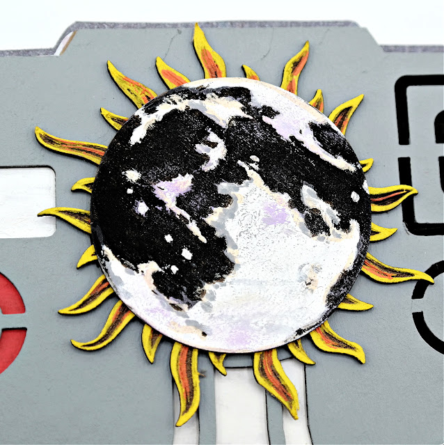 Document the memories of the stunning beauty of a solar eclipse in a polaroid inspired chipboard mini album with a moon covered sun embellishment.