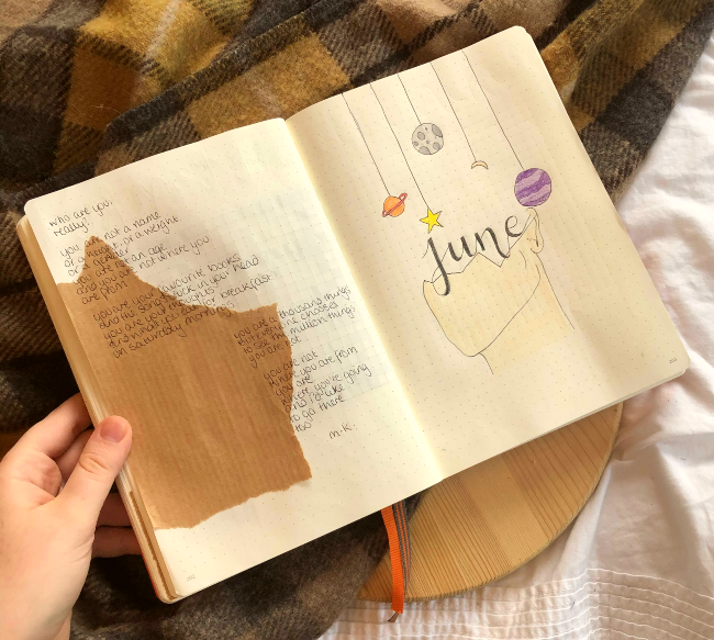 Dotted bullet journal with poetry written on the left hand side and a hand drawn outline of a face under some planets on the right