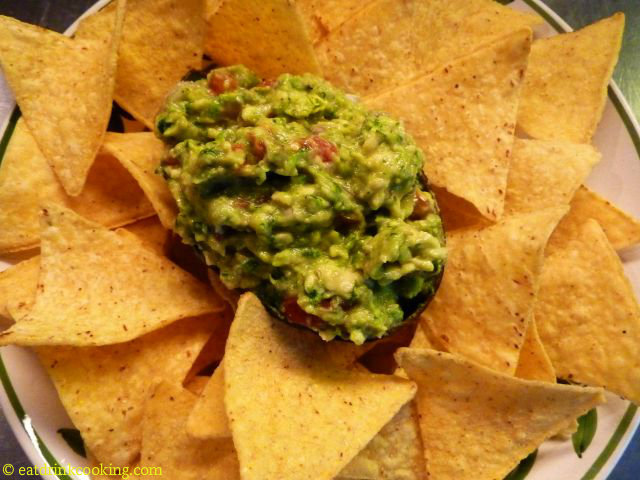 Guacamole in der Avocadoschale mit Tortilla Chips "natural" auf einem Teller angerichtet