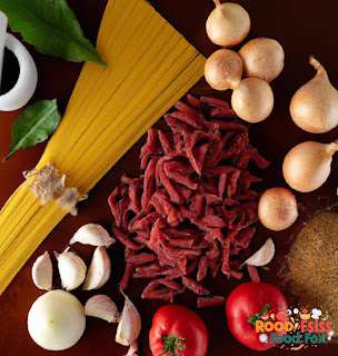 A photo of the ingredients used to make the Bolognese sauce, including ground beef, onion, garlic, canned tomatoes and tomato paste, dried herbs, and red wine. The ingredients are arranged in a neat and organized manner.