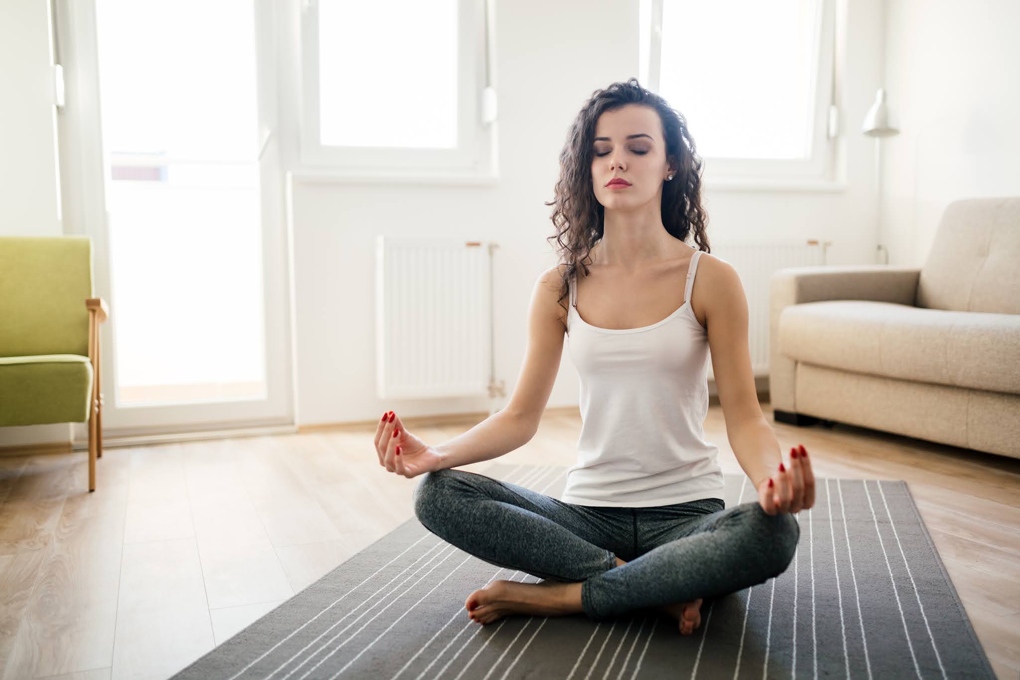 The Benefits of Meditation - Young attractive woman relaxing and practicing yoga