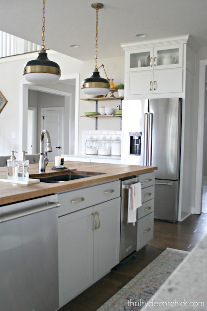 Gray island with wood countertops and sink