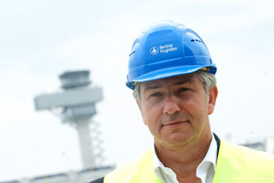 OB Wowereit mit Helm vor dem Terminal des BER Flughafens