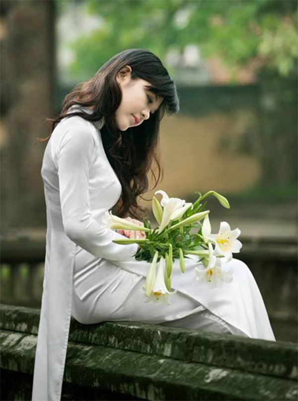 Thiếu nữ ngồi áo dài trắng hoa loa kèn