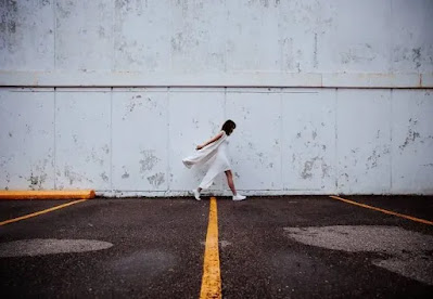 An image of a girl near the wall with a yellow strip- sad girl dp