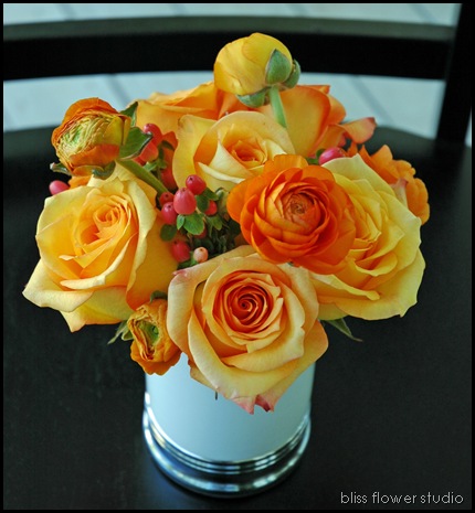 Latin Beauty 39 roses orange ranunculus and peach hypericum berries in a 