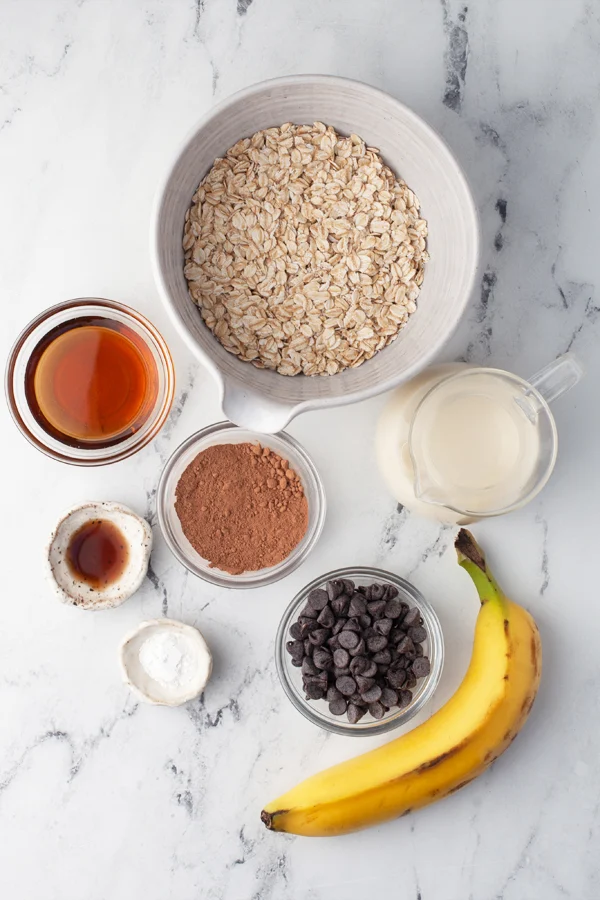 Fresh and wholesome ingredients for making delectable Brownie Baked Oatmeal - Rolled oats, almond milk, cocoa powder, maple syrup, and more