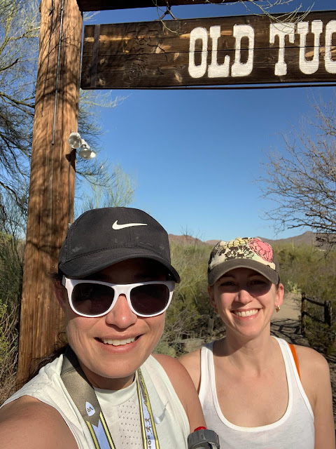 two women in the desert under a Tucson sign