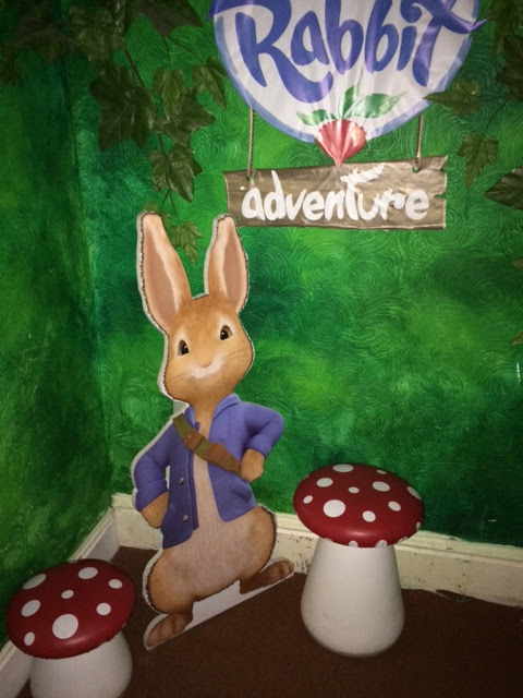 Peter Rabbit cutout against green background between toadstools 