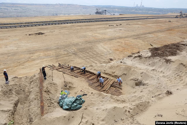 Αρχαιολόγοι κοντά στο Kostalac της Σερβίας, σκάβουν με κόπο την άμμο και το χώμα από τα ξυλόγλυπτα ενός αρχαίου ρωμαϊκού πλοίου στις 2 Αυγούστου. Το πλοίο ανακαλύφθηκε από ένα πλήρωμα εκσκαφέα στο ορυχείο Drmno.