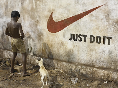 Just do it, skrivet på en vägg i något fattigt land. En gatpojke kissar på väggen och en hund tittar nyfiket på