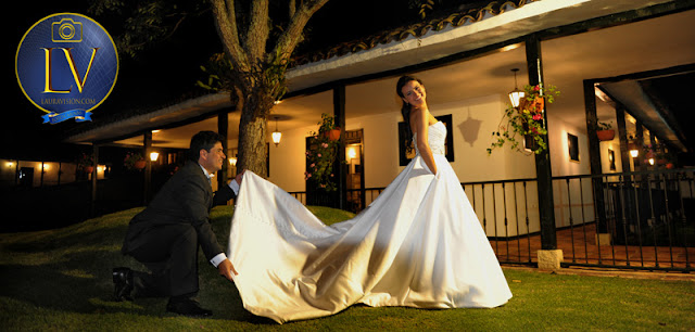 novio arregla cola del vestido de la novia.