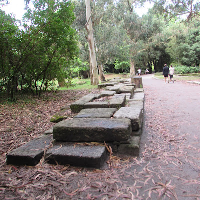 muro de granito e pessoas passeando no parque