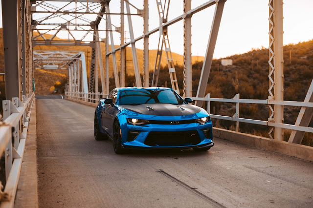 Chevrolet Camero a car blue with black hood on top of a bridge. One of the many competitor of electric car phev
