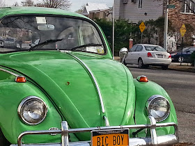 A green Volkswagen Bug parked on a side street in Staten Island with a license plate that reads Bic Boy